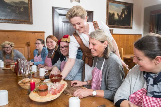 Gruppo che partecipa a un laboratorio culinario tradizionale in una sala da pranzo rustica