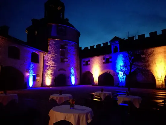 Cortile storico illuminato con luci blu e arancioni di notte
