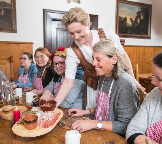 Gruppe bei einem traditionellen Kochkurs in rustikalem Speisezimmer