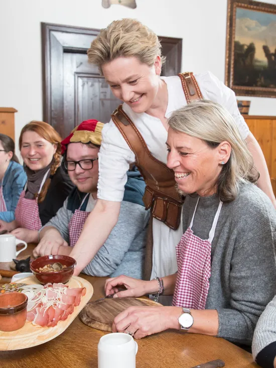 Gruppe bei einem traditionellen Kochkurs in rustikalem Speisezimmer