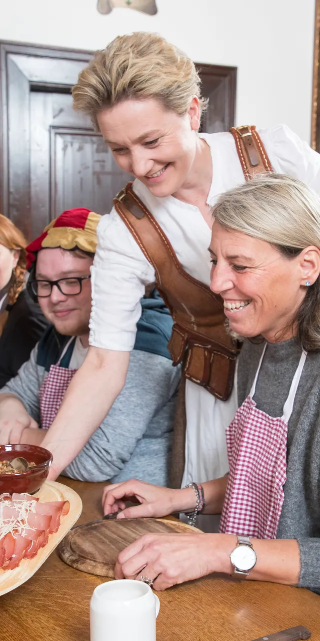 Gruppe bei einem traditionellen Kochkurs in rustikalem Speisezimmer